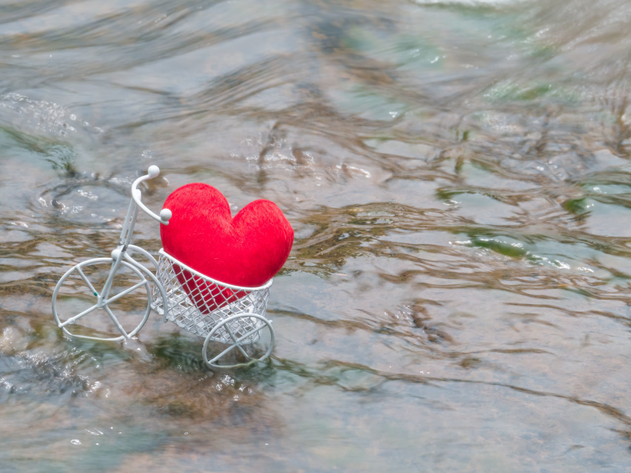 HIGH ANGLE VIEW OF HEART SHAPE MADE OF RED WATER