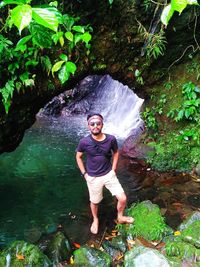 Full length of man standing on rock in forest