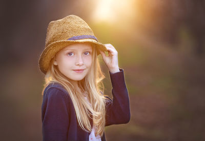 Portrait of young woman wearing hat standing outdoors