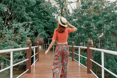 Rear view of woman standing on footbridge