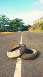 Close-up of shoe on road against sky