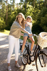 Smiling mother with daughter outdoors