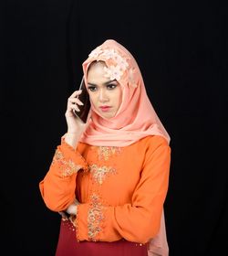 Woman standing against black background