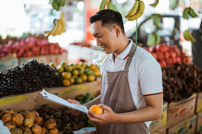 Man holding fruits at market stall