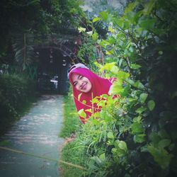 Portrait of woman standing by plants