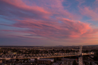 Cityscape against cloudy sky at sunset