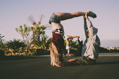 Rear view of woman with arms raised standing on street