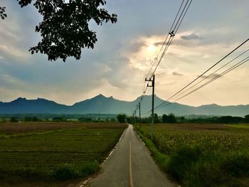 Road amidst field against sky