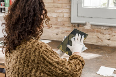 Female artist preparing a plate for an art print.