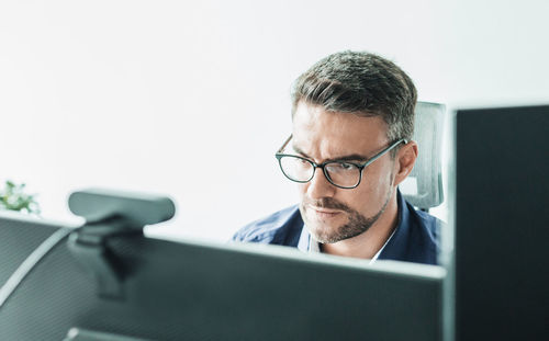 Side view of young man using laptop at home