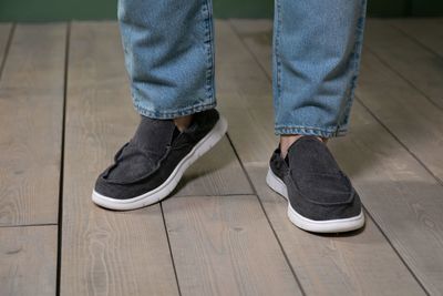 Low section of man standing on wooden floor