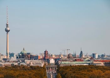 Tower and buildings in city against sky