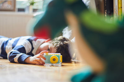 A boy takes photos of his toys with his camera