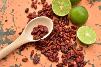 Cool green limes hot red dried chili peppers on tabletop