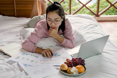 Young woman using mobile phone on table