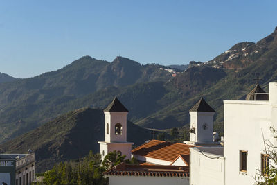 Houses by mountain against sky