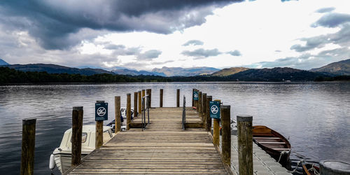 Wooden pier over lake against sky