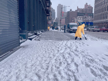 Rear view of people walking on snow covered landscape