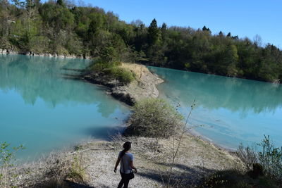 Rear view of man standing by lake