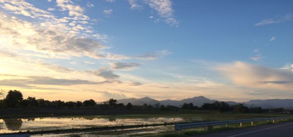 Scenic view of agricultural field against sky during sunset