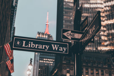 Road sign by buildings in city