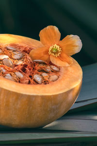 Close-up of orange flower in bowl on table