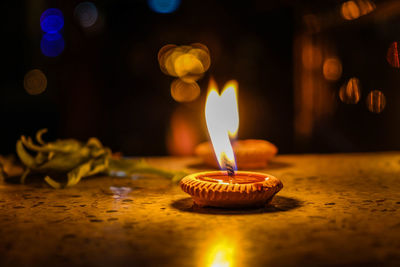 Close-up of lit candle on table