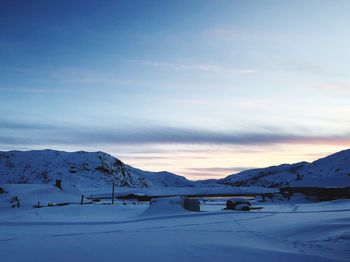 Scenic view of snow covered mountains against sky during sunset