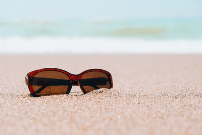 Close-up of sunglasses on beach