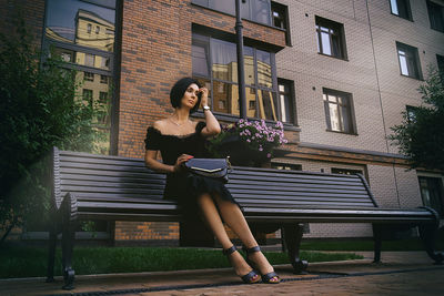 A pretty charming middle-aged woman in a black dress strolls through the city park and street