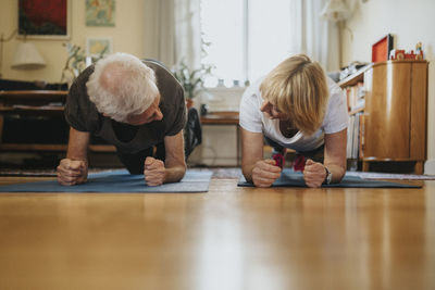 Senior couple doing planks at home