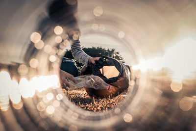 Midsection of girl collecting garbage on grass