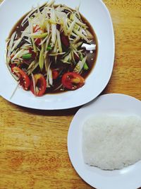 Topview of papaya salad and sticky rice serve on the table.