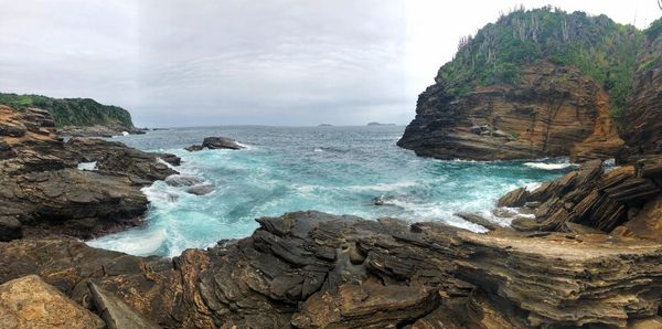 Scenic view of rocks in sea against sky