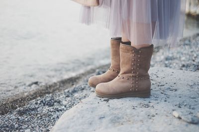 Low section of woman standing on rock