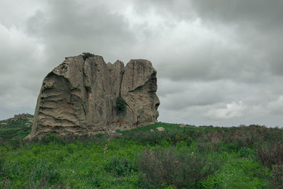 Rocks on field against sky