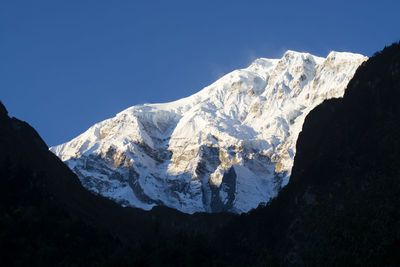 Scenic view of snowcapped mountains against clear sky