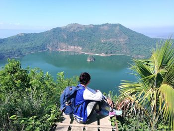 Side view of woman with backpack looking at lake