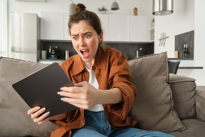 Young woman using digital tablet at home