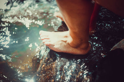 Low section of person relaxing on rock