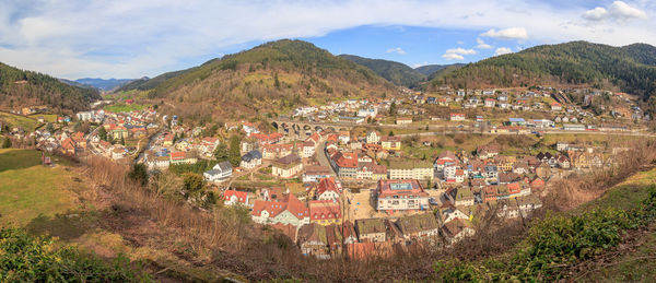 Aerial view of townscape and mountains against sky