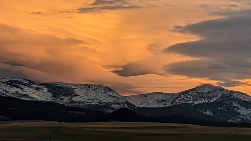 Scenic view of snowcapped mountains against sky during sunset