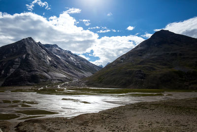 Scenic view of lake by mountains against sky