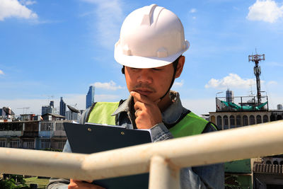 Man using smart phone against sky