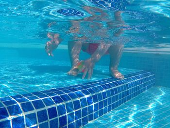 Low section of girl playing with toy in swimming pool