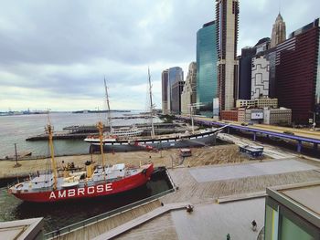 Ship moored in sea against buildings in city