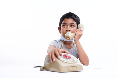 Portrait of boy holding ice cream against white background