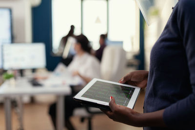 Midsection of businessman using digital tablet