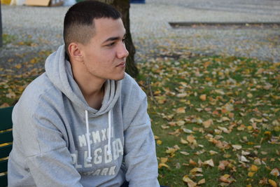 Portrait of young man in autumn leaves