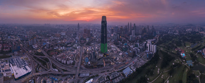 High angle view of modern buildings in city against sky during sunset